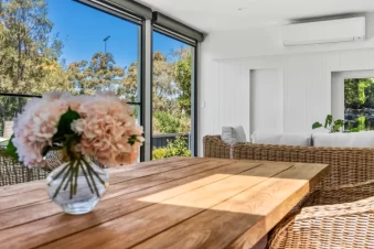 Outdoor dining area with wicker chairs and garden view.